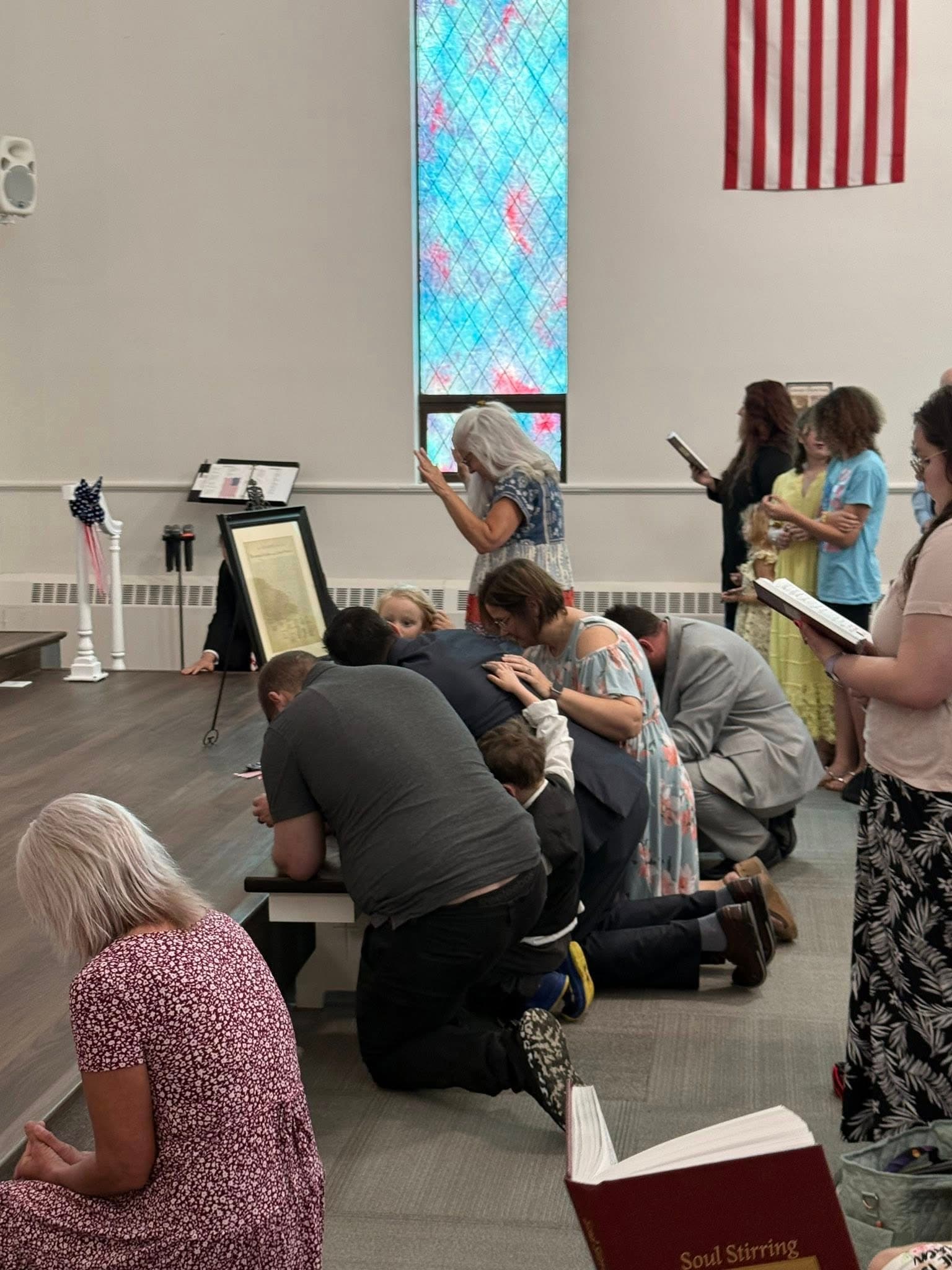 Gethsemane Church congregation praying together during a worship service in Pekin Illinois